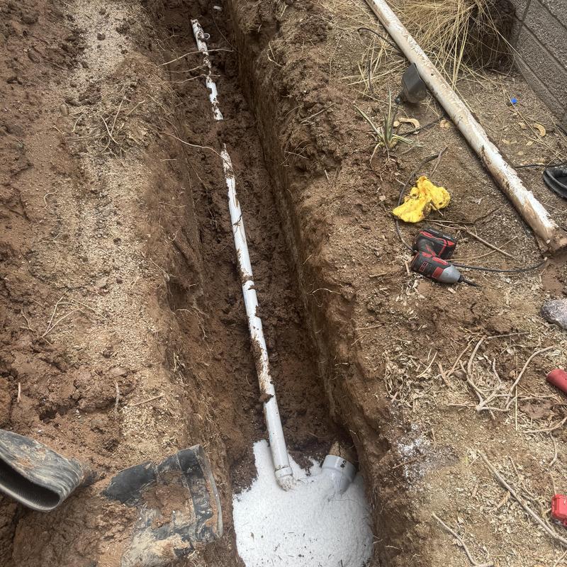 Laundry sewer line with trench in backyard dirt Laundry sewer line with trench in backyard dirt