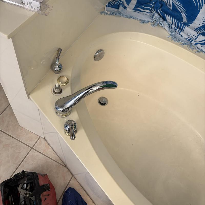 Bathtub faucet cartridge installation with tools nearby