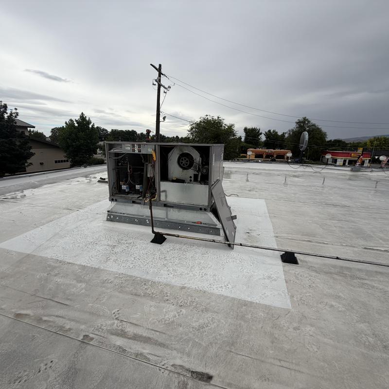 Rooftop HVAC unit with open access panel on roof