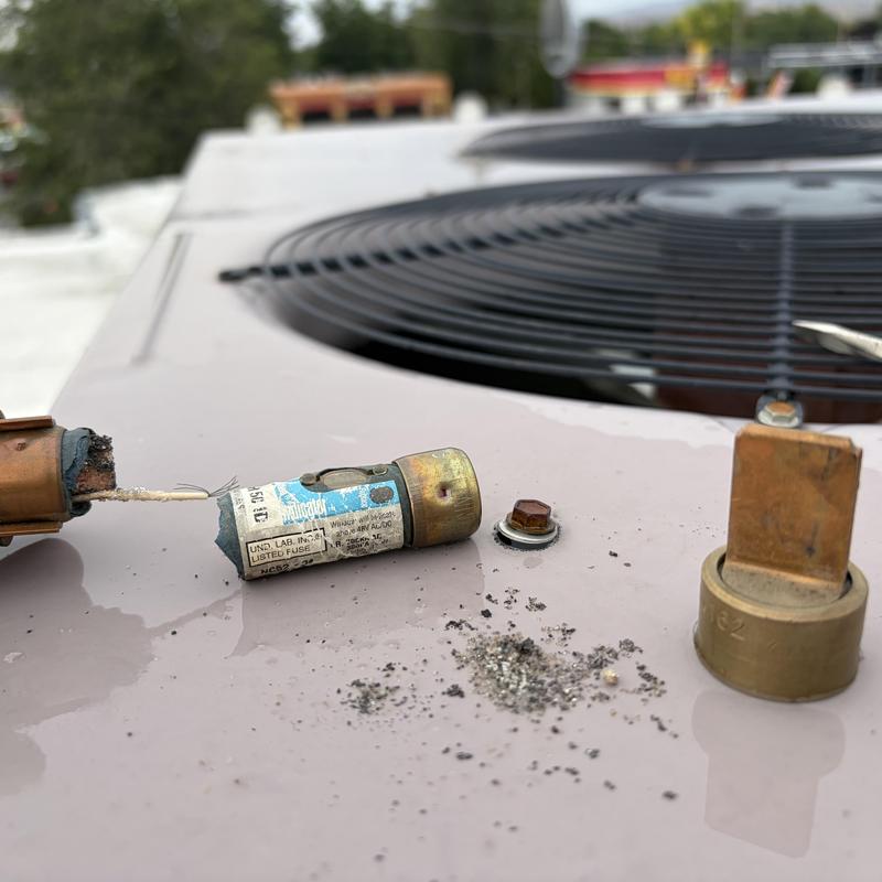 HVAC rooftop unit blown fuse and debris on panel