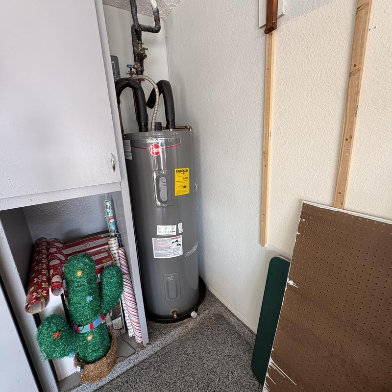 Water heater with insulated pipes in utility closet