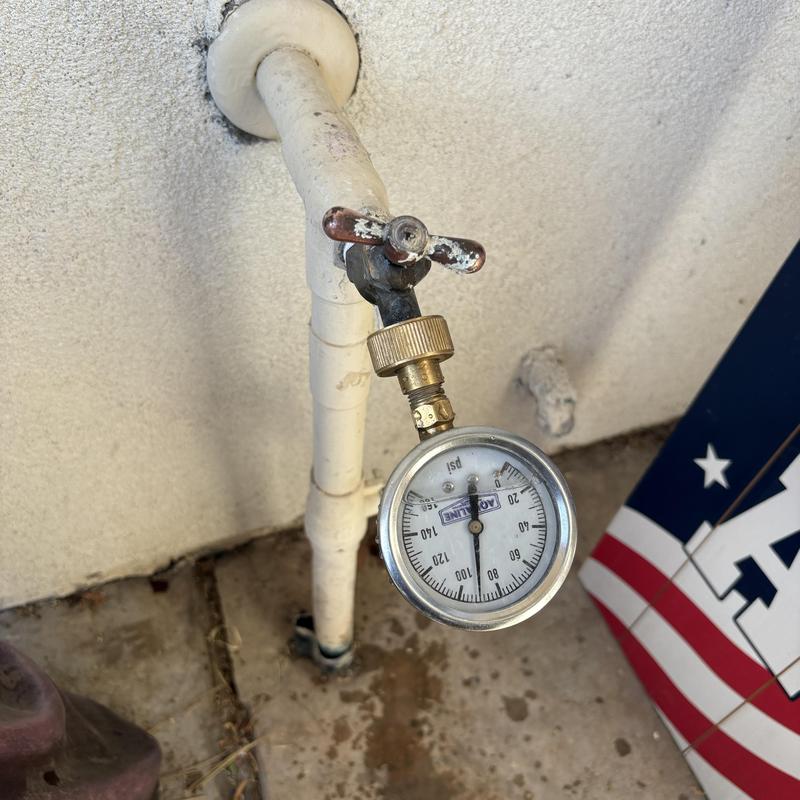 Pressure regulator valve with attached gauge on pipe