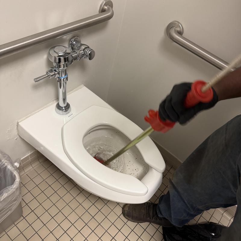 Toilet drain auger cleaning with flush valve in restroom Toilet drain auger cleaning with flush valve in restroom