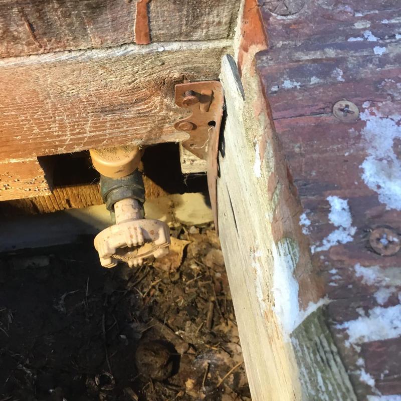 Outdoor hose bib valve attached to house framing