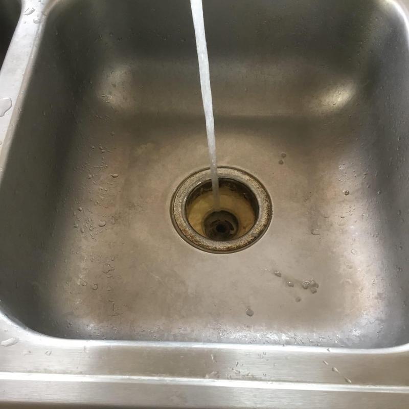 Kitchen sink drain with water flow and rust buildup