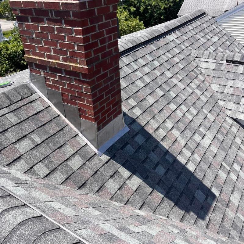 Asphalt shingle roof and brick chimney flashing New London