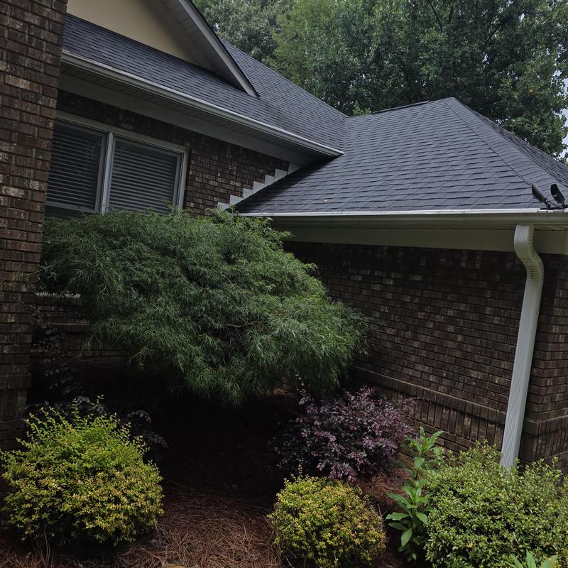 Asphalt shingle roof and gutter on brick house exterior