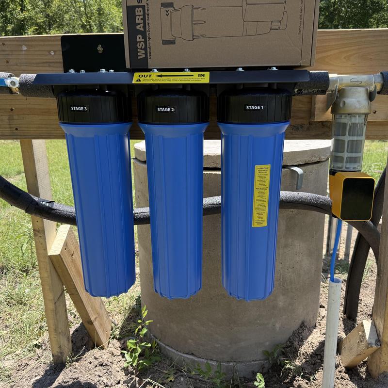 Whole house water filter system with three stages installed outdoors Whole house water filter system with three stages installed outdoors