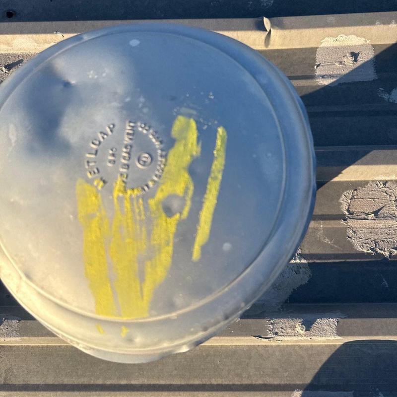 Metal roof vent cap with hail impact dents and markings