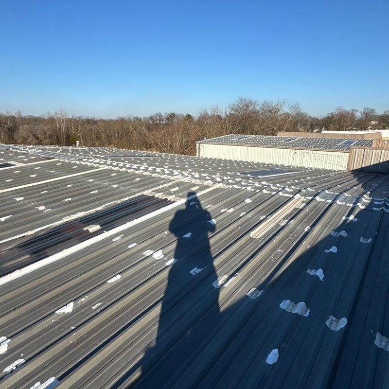 Metal roof with hail damage patches and shadow