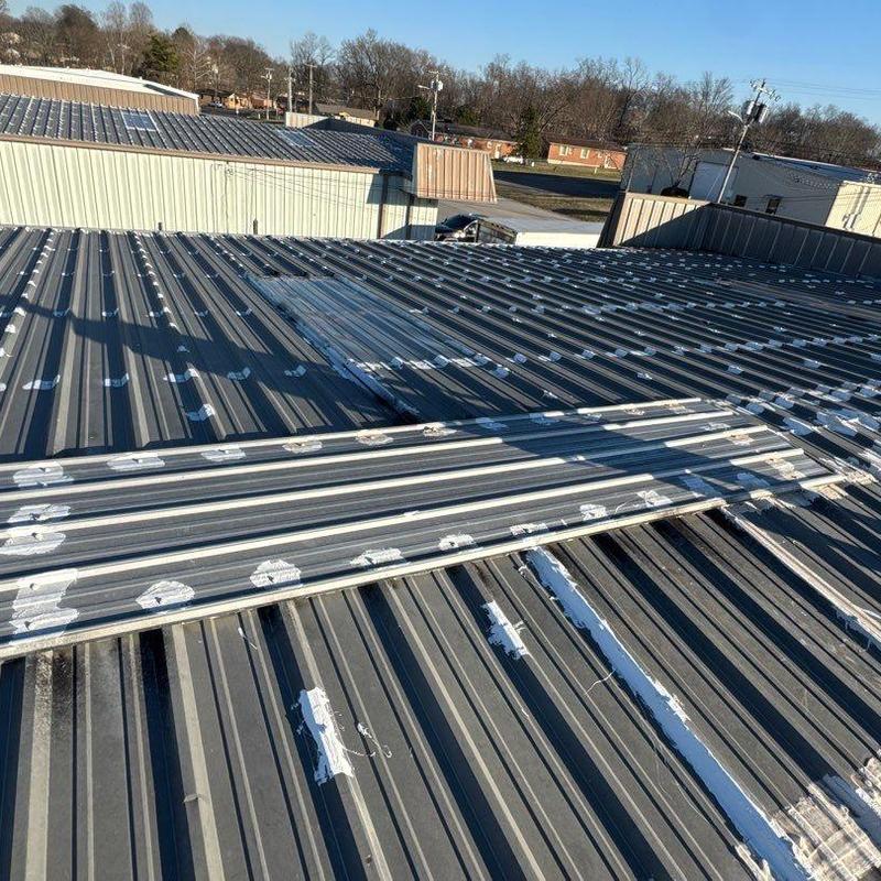 Metal commercial roof with hail damage spots