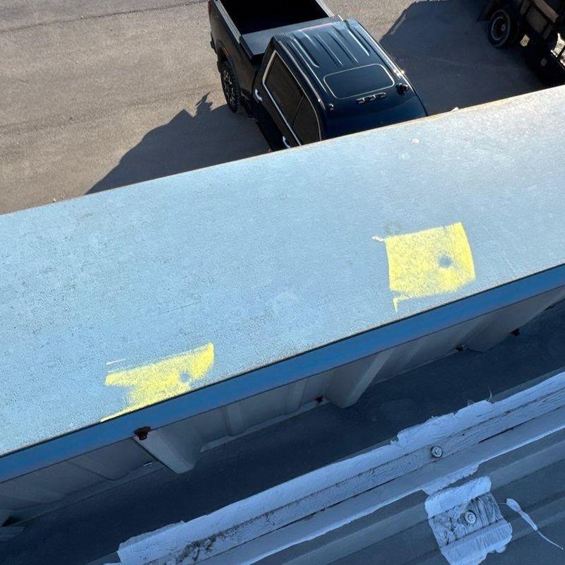 Commercial metal roofing with hail damage marked