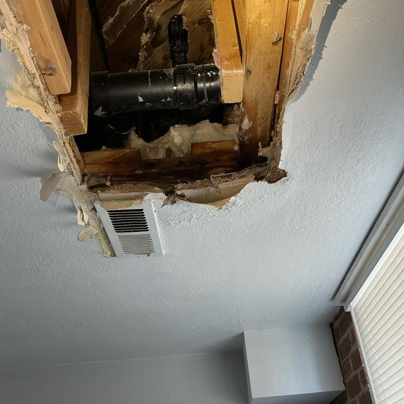 Tub drain pipe leak with ceiling damage exposed above vent