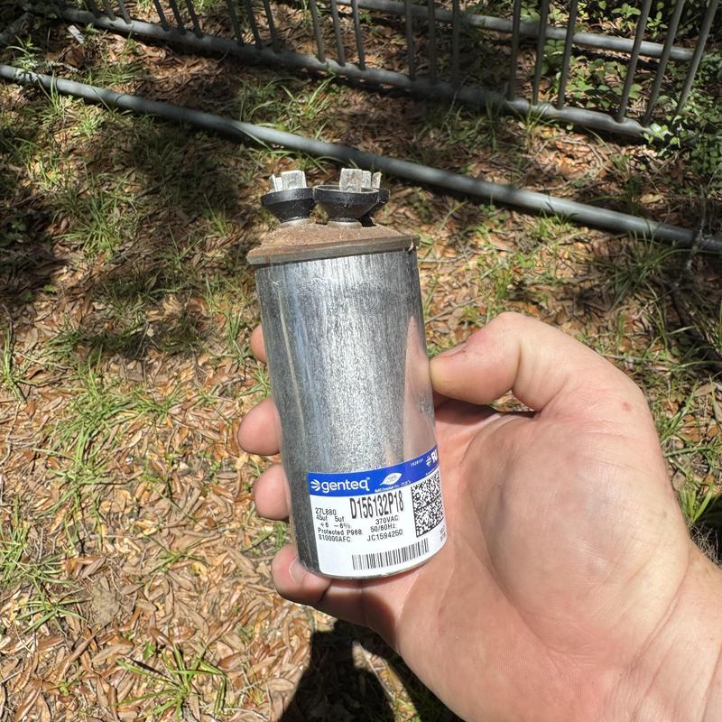 HVAC start assist capacitor held outdoors in hand