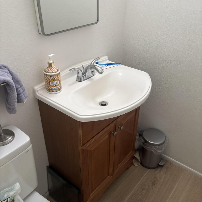 Bathroom sink faucet with wooden cabinet and mirror