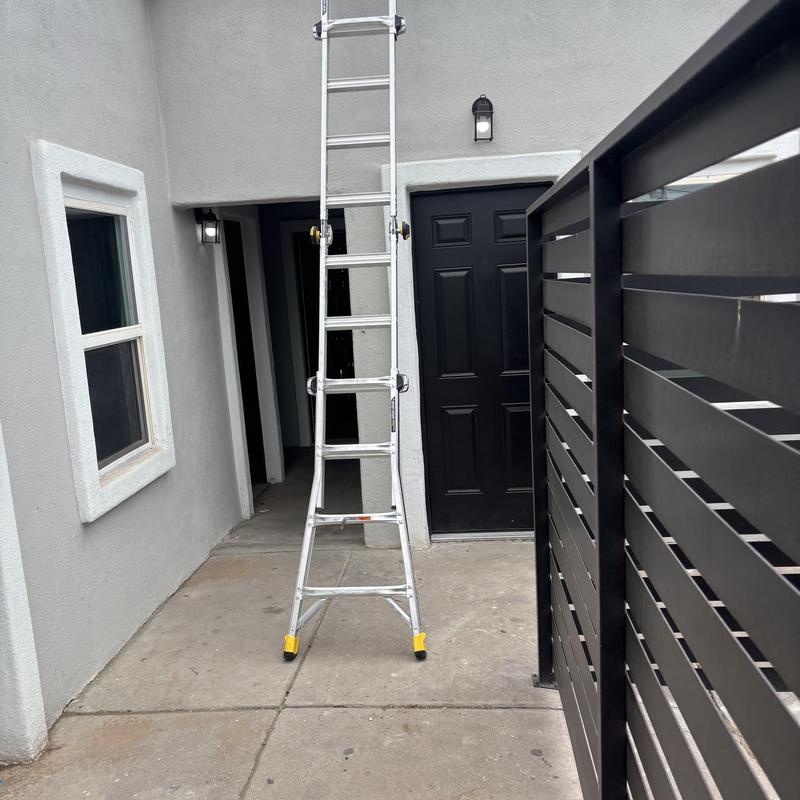 Ladder setup on outdoor walkway near entry door