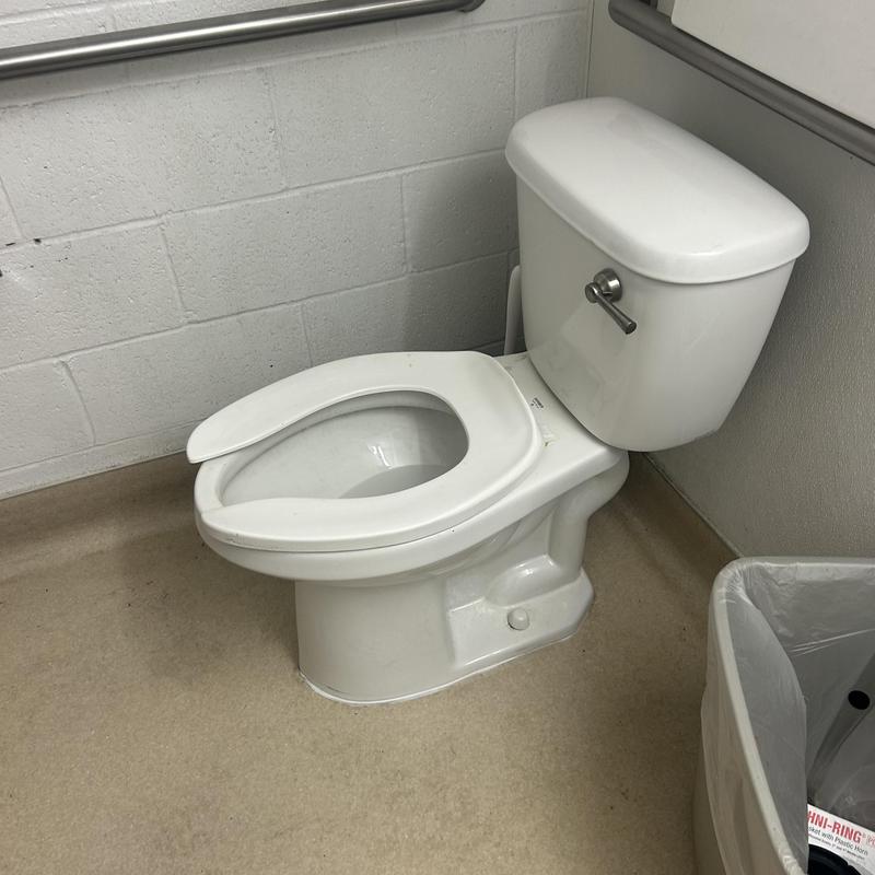 Commercial toilet auger clearing in restroom corner Commercial toilet auger clearing in restroom corner
