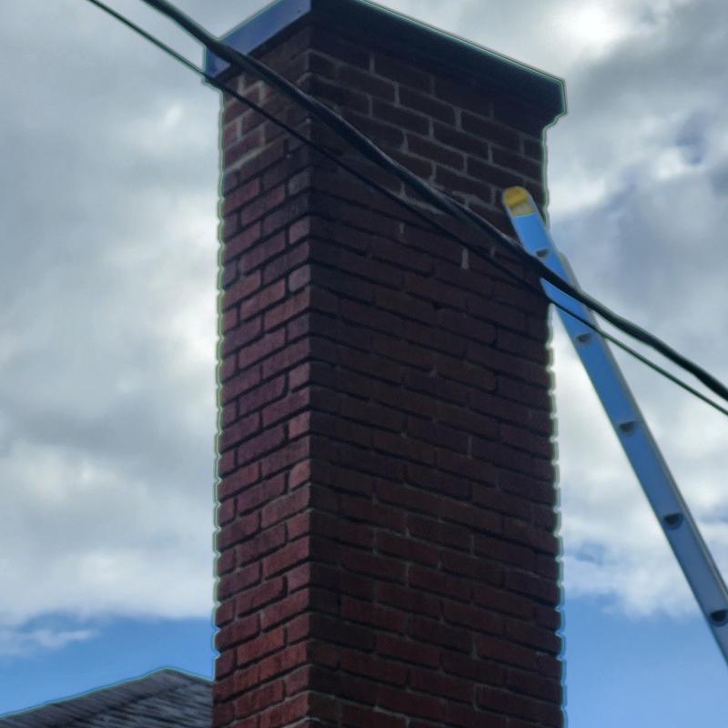 Brick chimney with handmade metal chimney cap and ladder