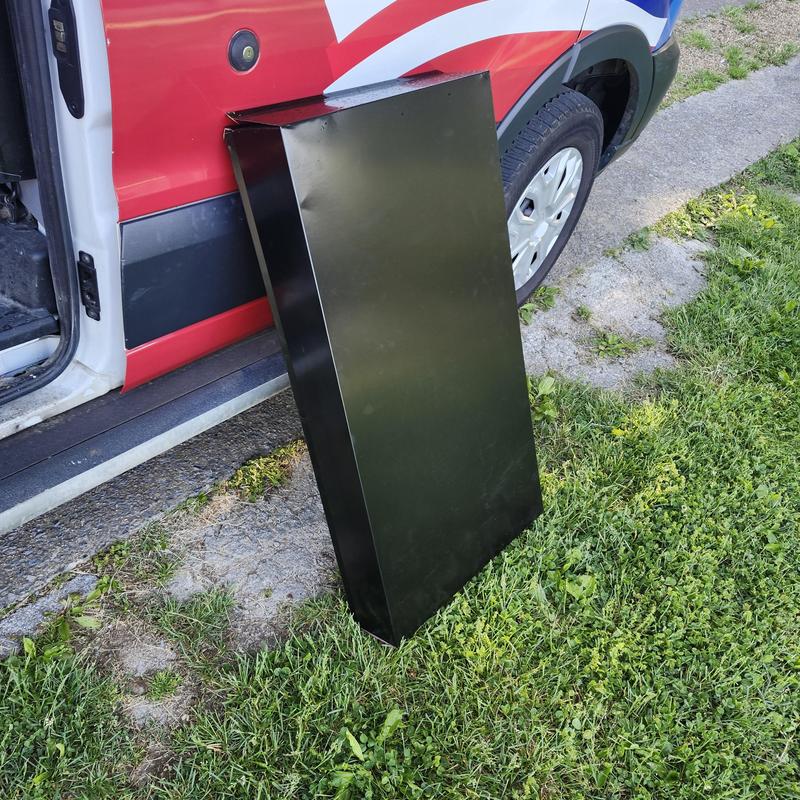 Metal chimney cap beside service vehicle on grass