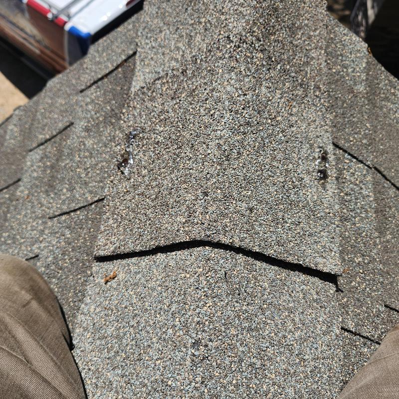 Roof shingles close-up showing damaged area near chimney