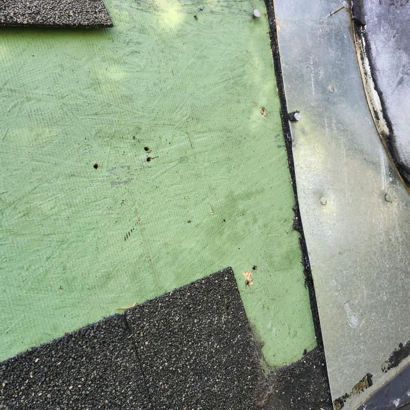 Chimney flashing and roof shingle repair close-up