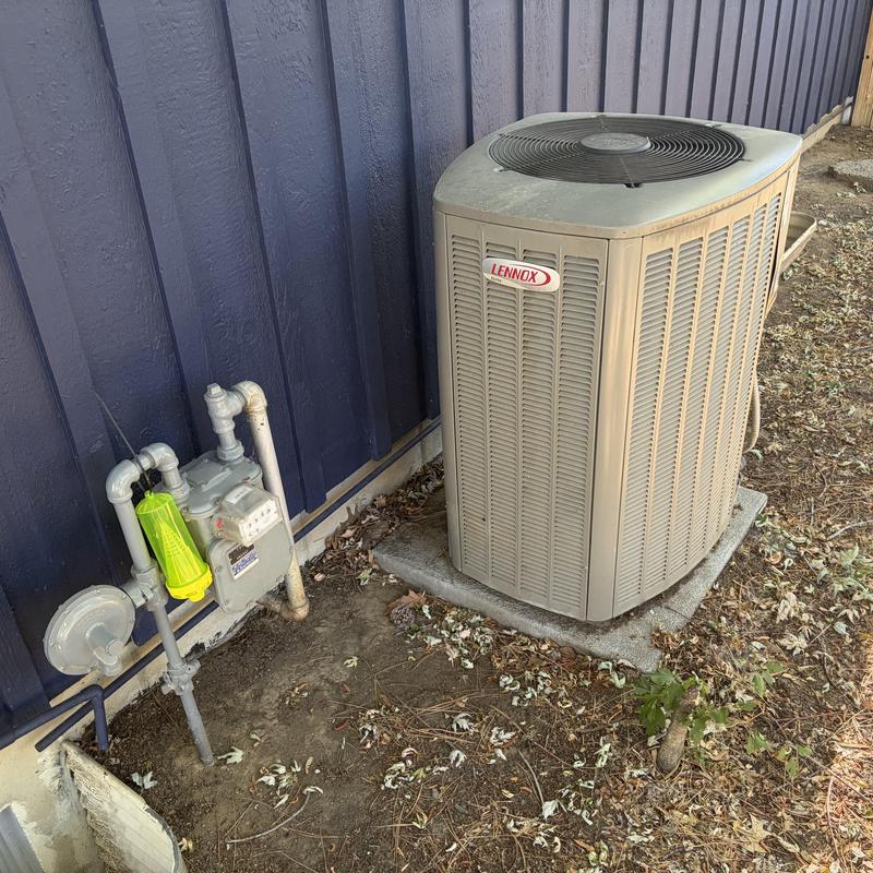 Outdoor Lennox air conditioning condenser unit near house Outdoor Lennox air conditioning condenser unit near house