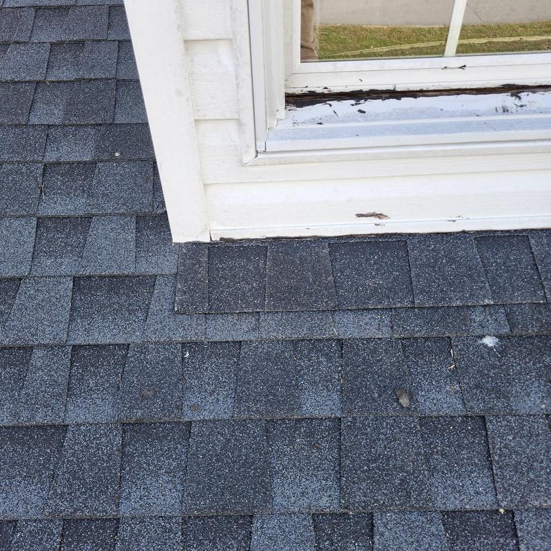 Roof shingles near dormer window with aging damage