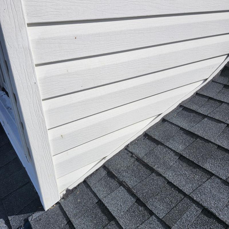 Asphalt shingles near dormer siding on roof edge
