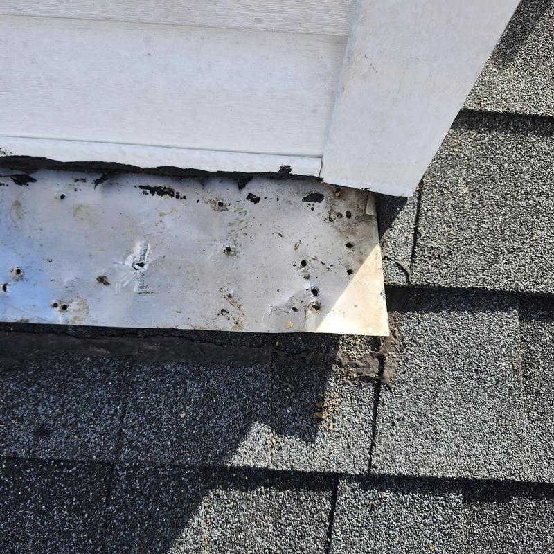 Dormer metal flashing and shingles near leak site