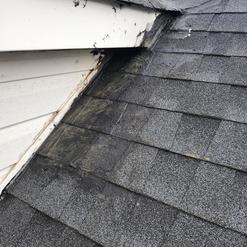 Dormer roof shingles with water damage and wear
