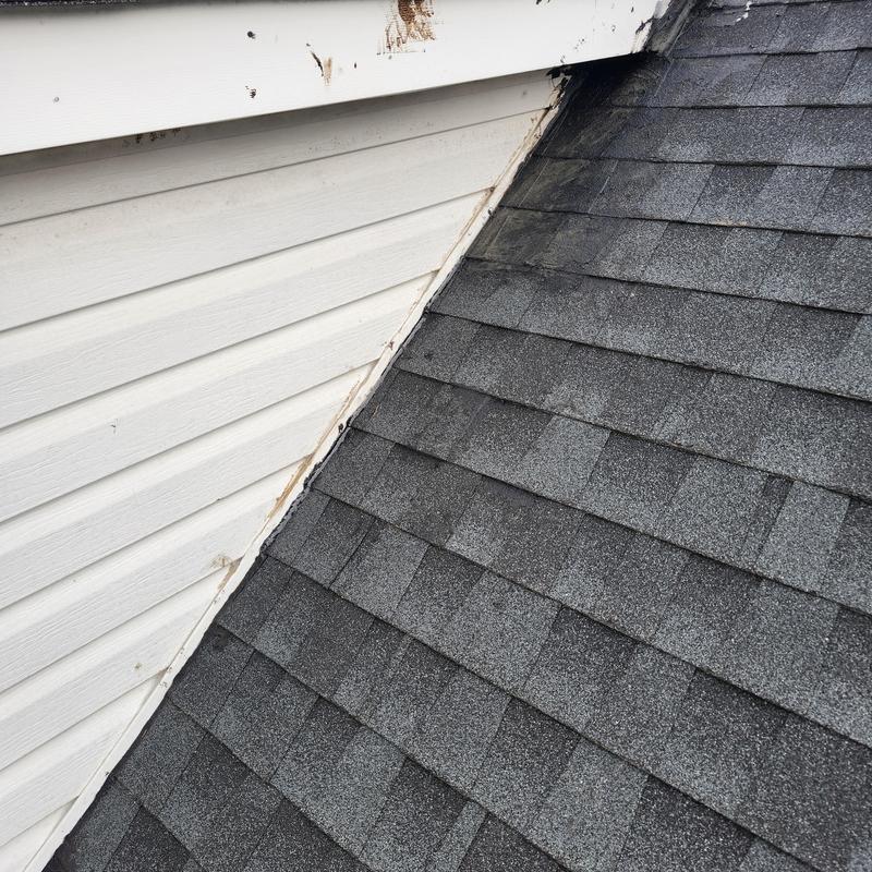 Shingles on roof near dormer with leak signs