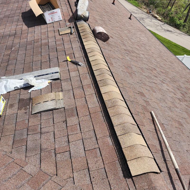 Ridge cap shingles and aged roof shingles on repair
