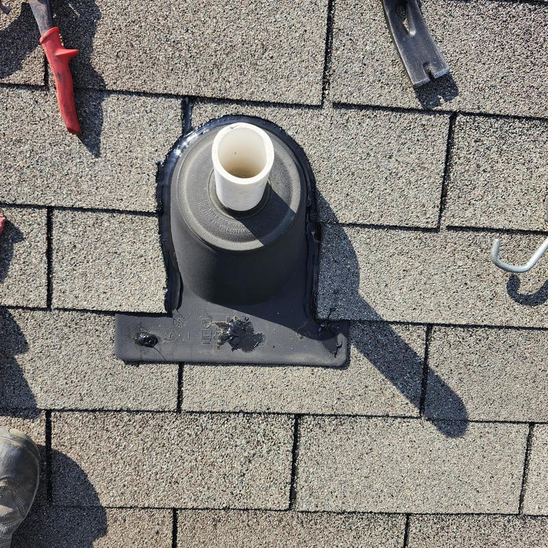 Roof pipe flashing with new sealant on asphalt shingles