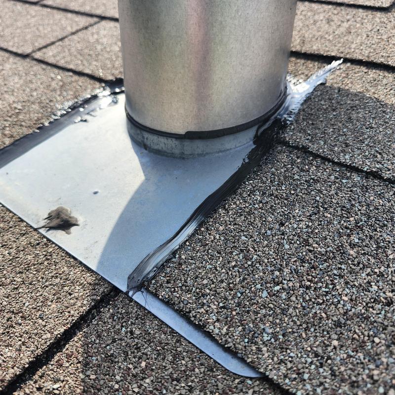 Roof vent flashing with sealant on asphalt shingles
