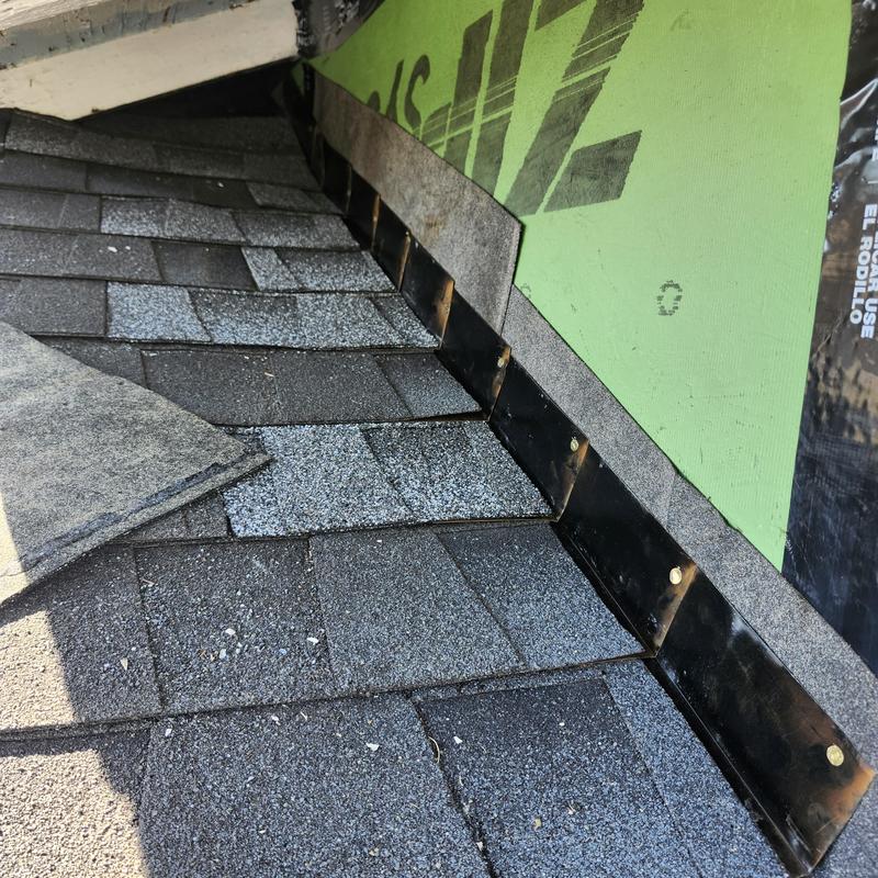 Roof shingles and metal flashing installation near wall