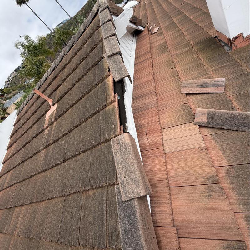 Flat roof tiles with broken and misplaced sections Flat roof tiles with broken and misplaced sections