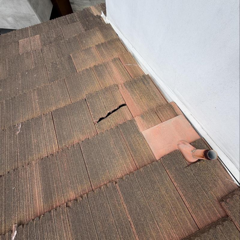 Flat tile roof with cracked tile near vent pipe Flat tile roof with cracked tile near vent pipe