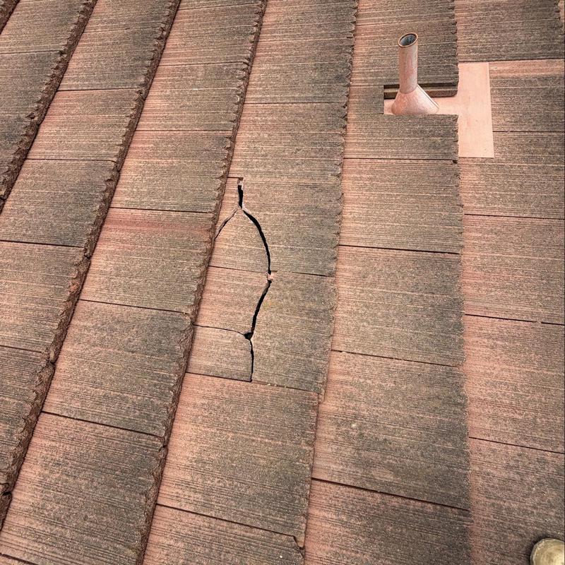 Flat roof tiles with visible crack and damage Flat roof tiles with visible crack and damage
