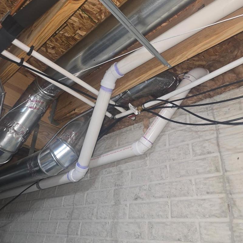 PVC discharge line installation in basement ceiling