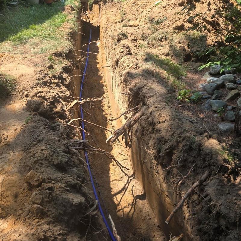Water service line installation in deep trench outdoors