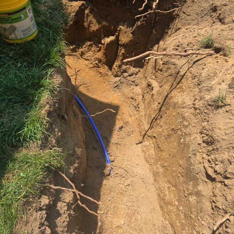 Blue water service pipe installed in trench outdoors