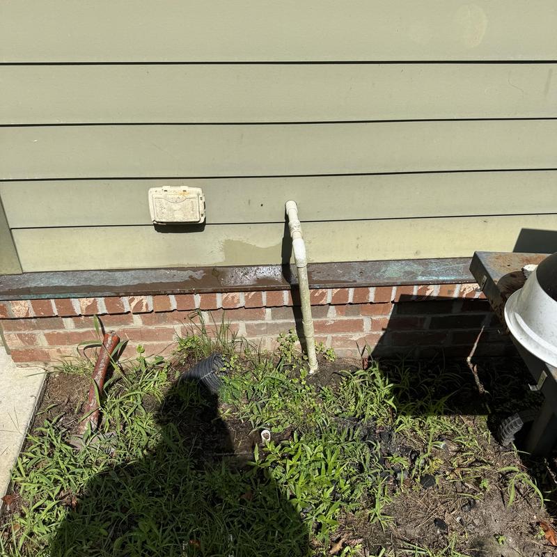 AC drain line outside house with water pooling