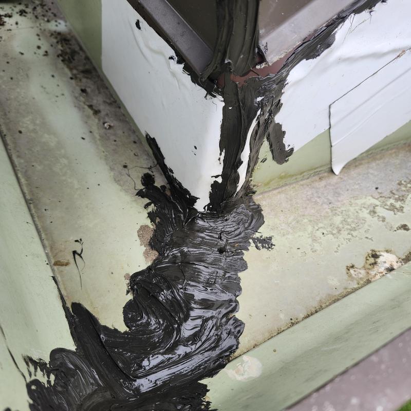 Roof flashing with black sealant applied at corner joint