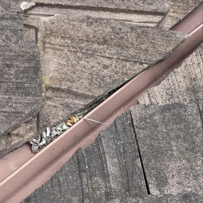 Roof flashing gap with debris and damaged shingles Roof flashing gap with debris and damaged shingles