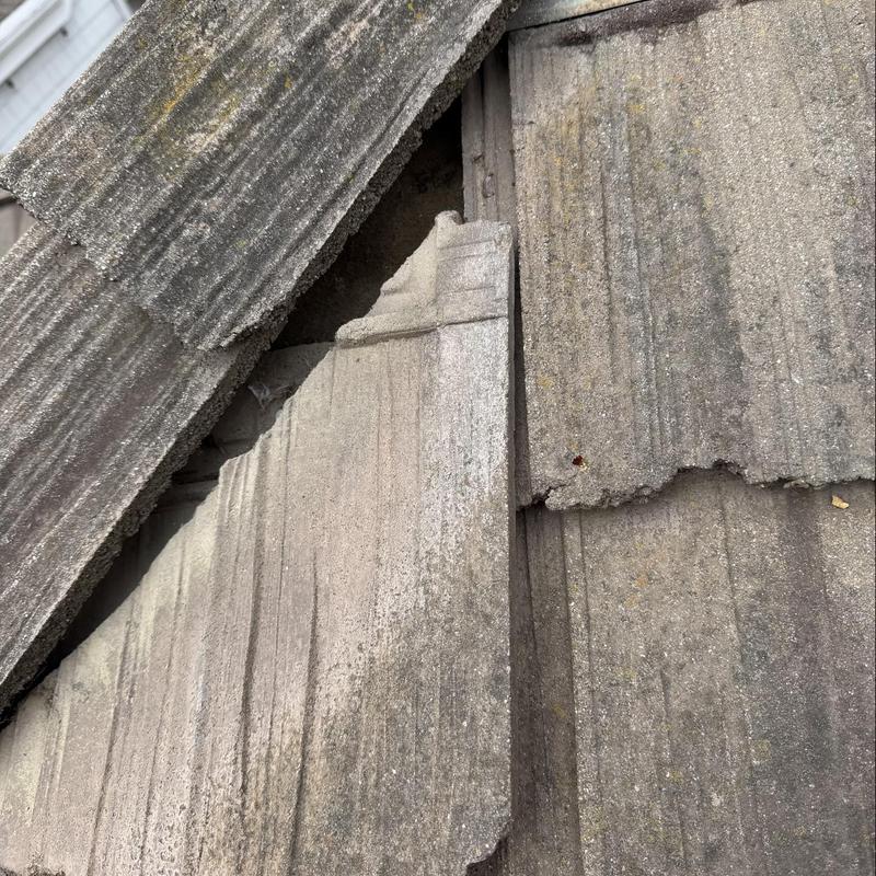 Concrete roof tiles with visible damage and wear Concrete roof tiles with visible damage and wear