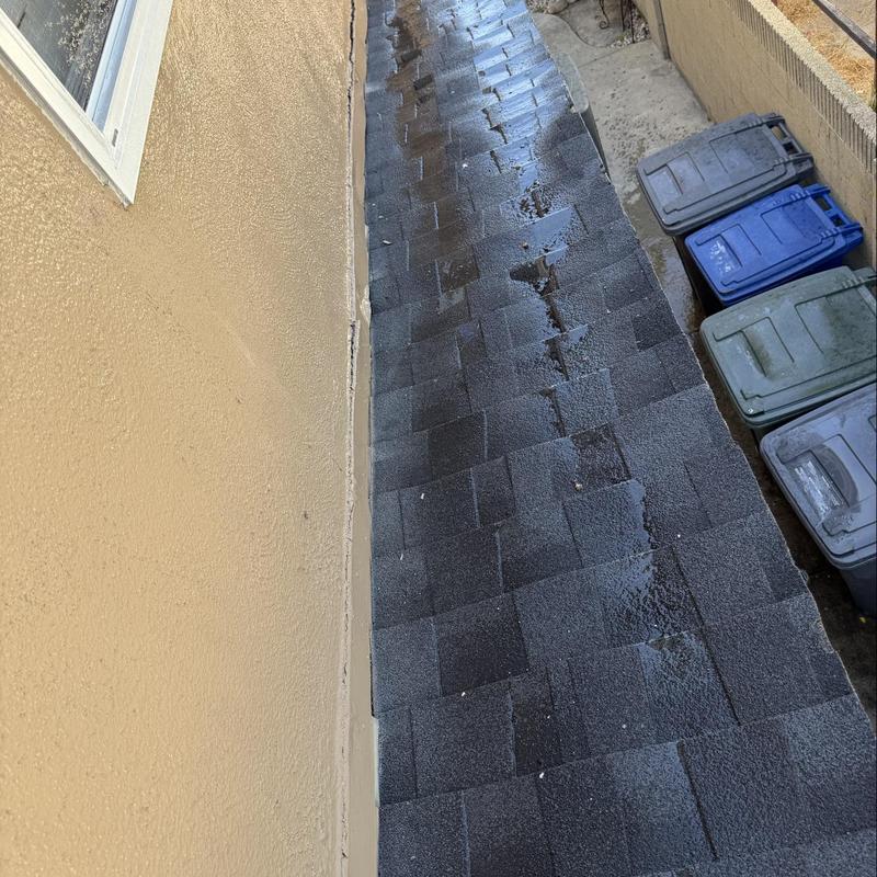 Asphalt shingle roof with water damage near wall Asphalt shingle roof with water damage near wall