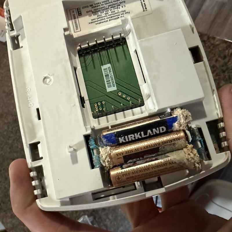 Thermostat battery compartment with leaked batteries Thermostat battery compartment with leaked batteries