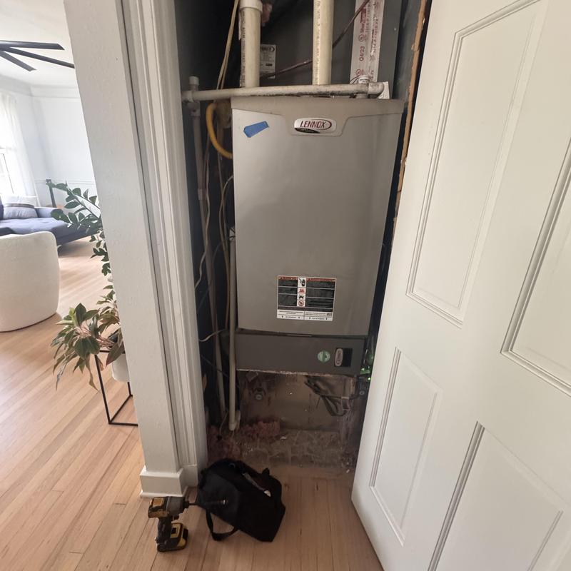 Gas furnace system in small closet with tools nearby