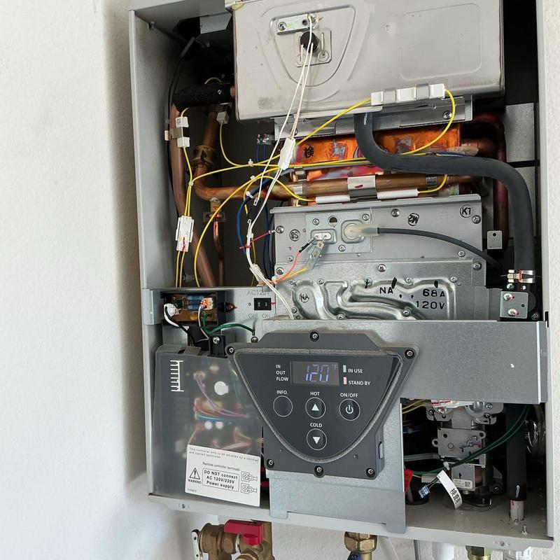 Tankless water heater interior with wiring and pipes