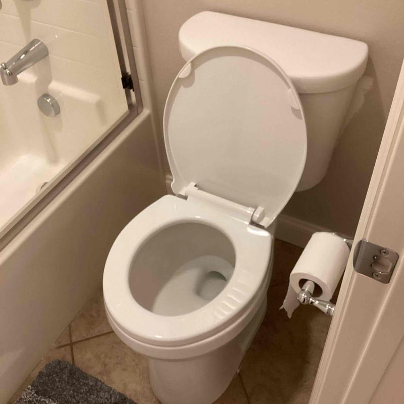 Toilet installation with open lid in bathroom corner